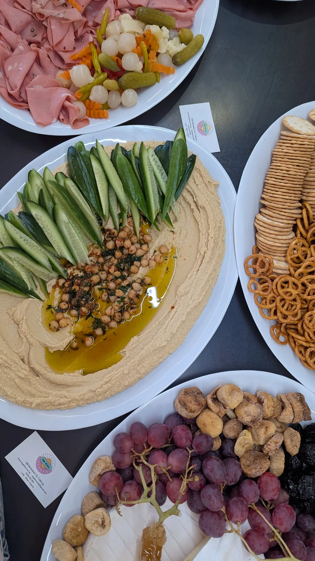 A grazing table with hummus, fruit, cheese and crackers.