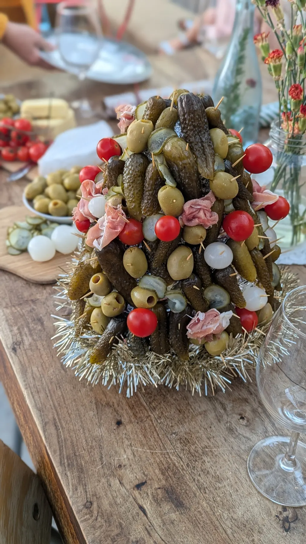 A table centrepiece of pickles, olives, tomatoes and cured meat.